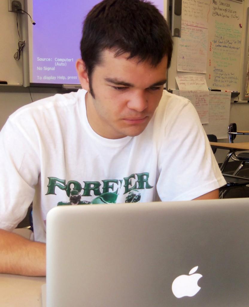 Senior Tyler Martin uses his assigned laptop to complete a class project.