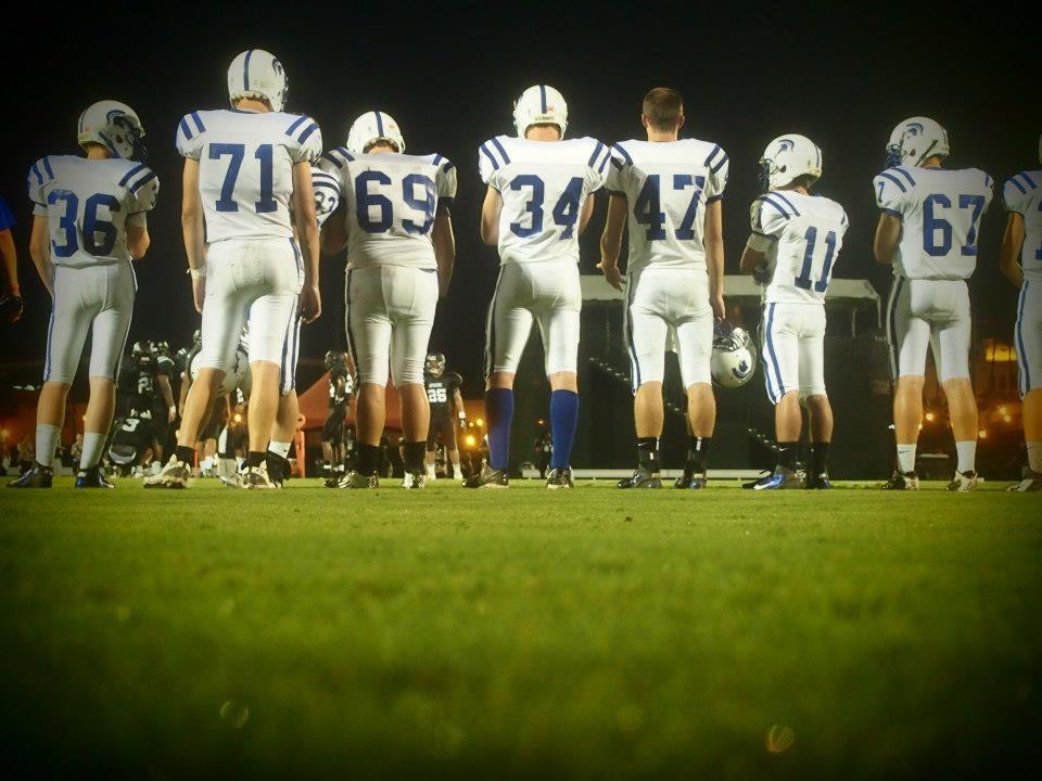 Spartan football players take the field. 