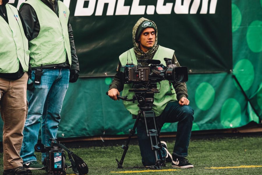 Pino films a Jets game from the sidelines.