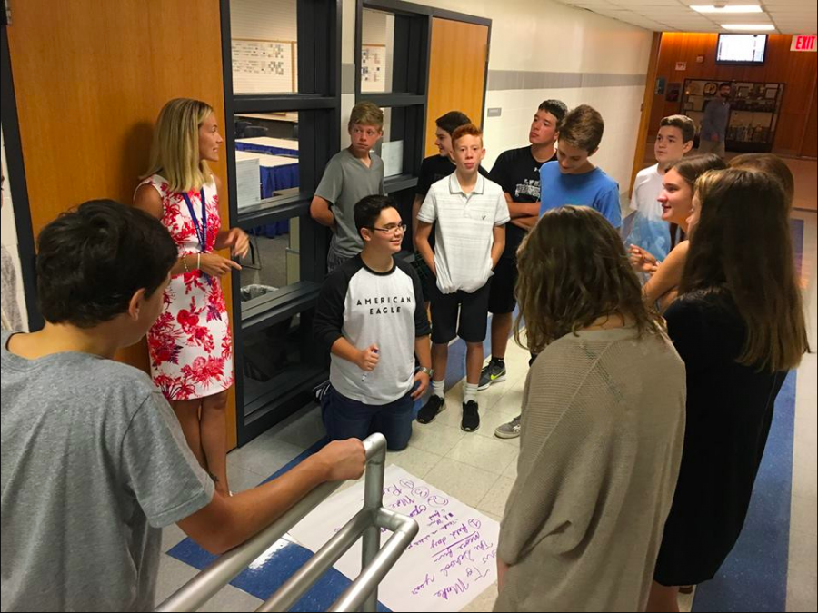 Freshmen work to generate ideas with the help of a teacher during a class assembly.