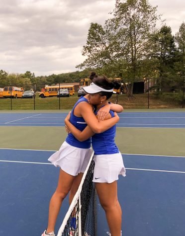 Senior Michelle Li (left) and sophomore Evelyn Wang (right) hug across the net after their District XI 3A semi-final match.