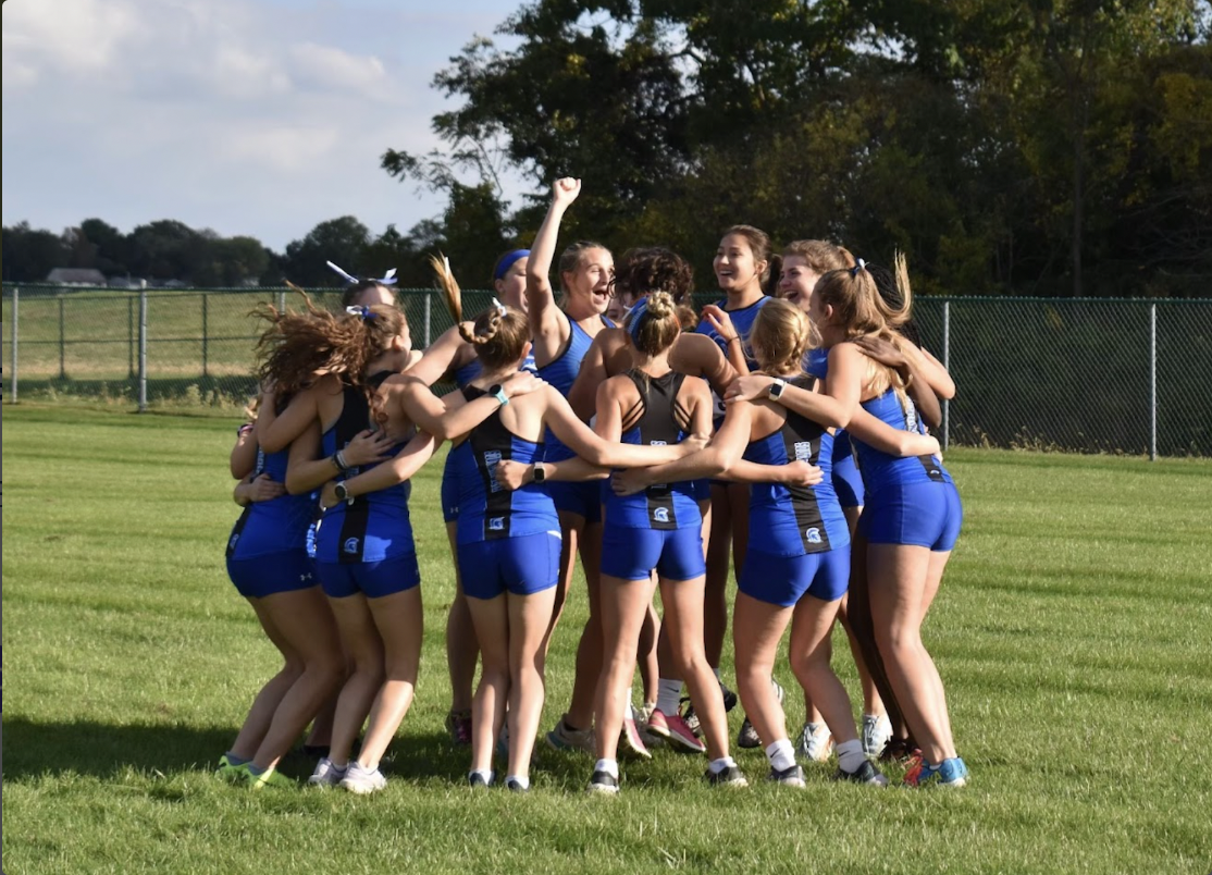 The girls jump in excitement before racing at a home meet.