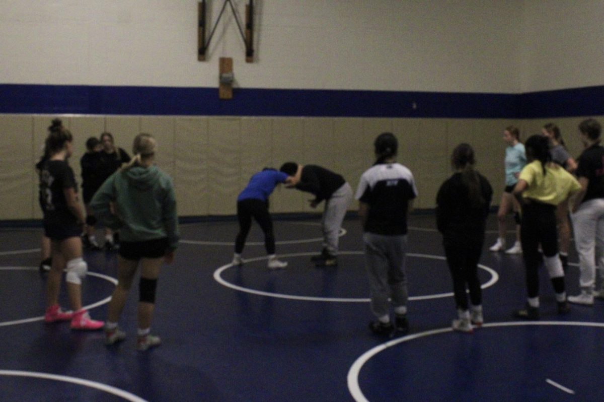 Girls wrestling team learns a new move during preseason practice.